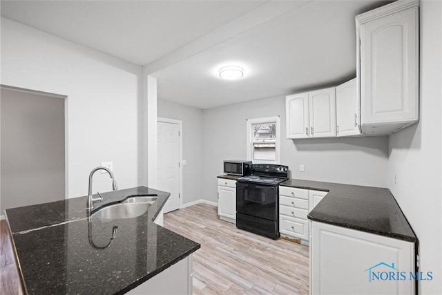 kitchen with electric range, sink, dark stone countertops, white cabinets, and light wood-type flooring