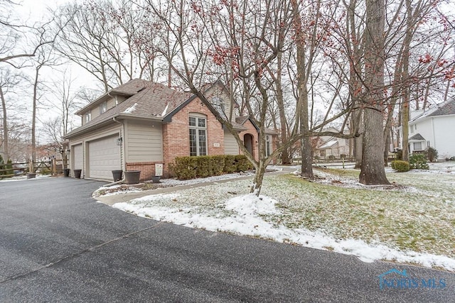 snow covered property with a garage