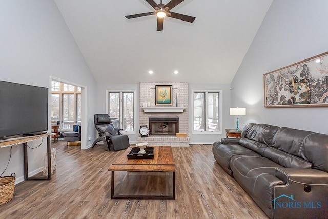 living room featuring hardwood / wood-style flooring, ceiling fan, a healthy amount of sunlight, and high vaulted ceiling