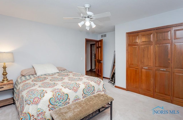 bedroom featuring light colored carpet, a closet, and ceiling fan