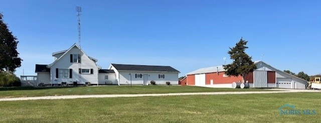 view of front of house featuring an outbuilding and a front lawn