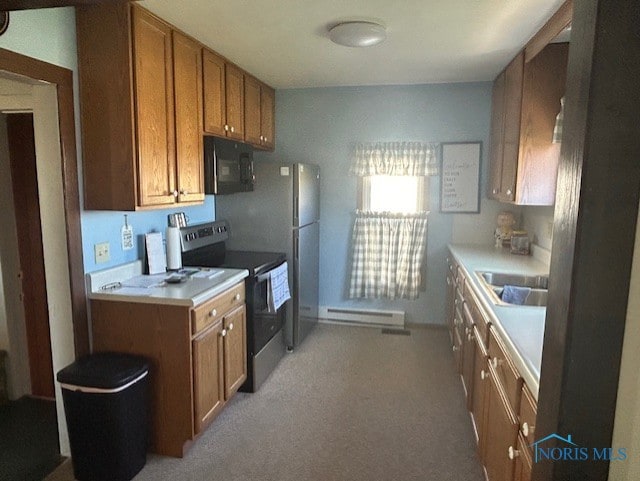 kitchen with stainless steel appliances, a baseboard heating unit, and sink