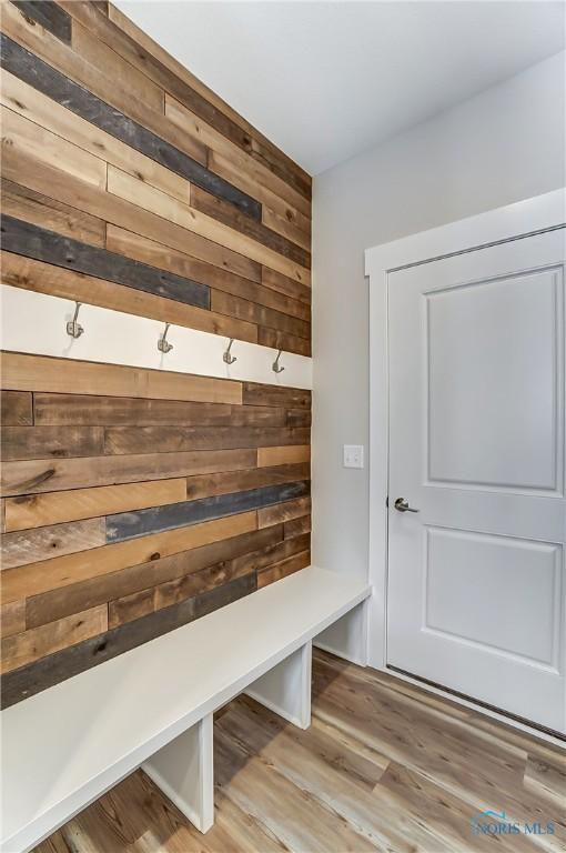 mudroom featuring wood walls and light hardwood / wood-style flooring