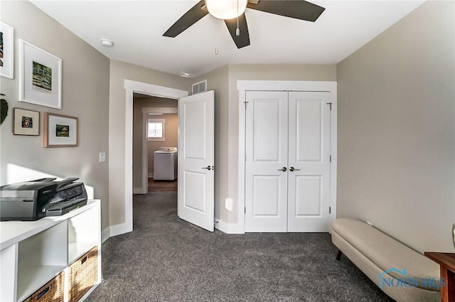 bedroom with ceiling fan, dark carpet, washer / clothes dryer, and a closet