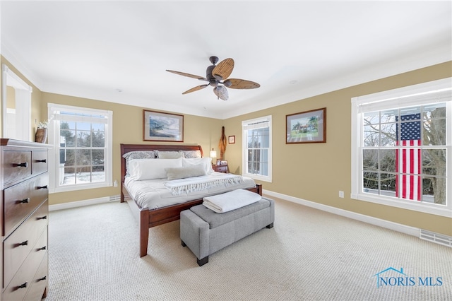 carpeted bedroom featuring multiple windows and ceiling fan