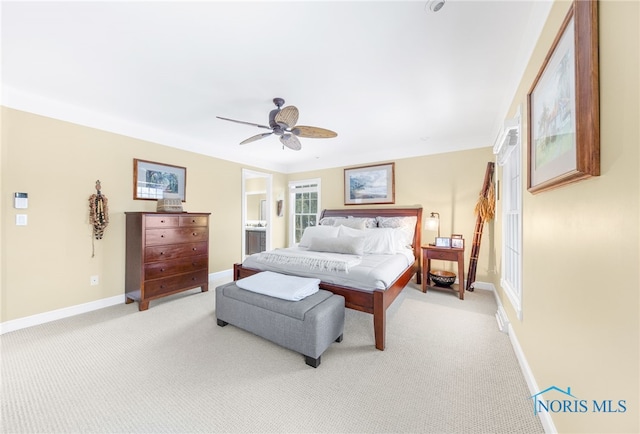 carpeted bedroom featuring ceiling fan and ensuite bathroom