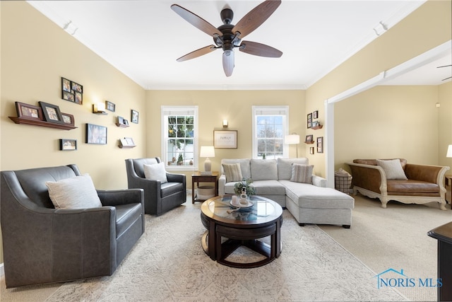 living room featuring ceiling fan, ornamental molding, and light carpet