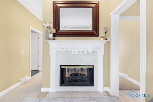 details featuring a tile fireplace, carpet, and ornamental molding