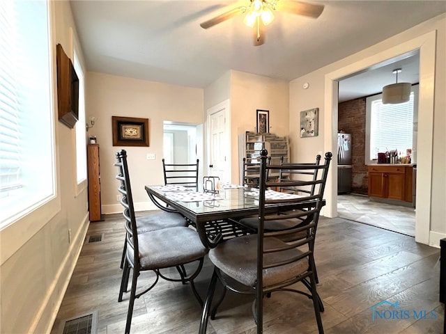 dining area featuring ceiling fan, a healthy amount of sunlight, and dark hardwood / wood-style floors