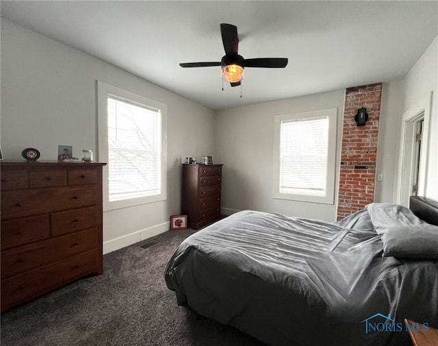 bedroom featuring multiple windows, dark colored carpet, and ceiling fan