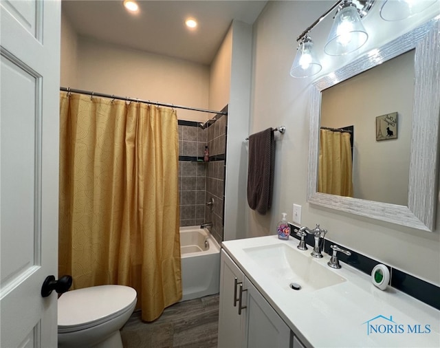 full bathroom featuring hardwood / wood-style flooring, vanity, shower / tub combo, and toilet