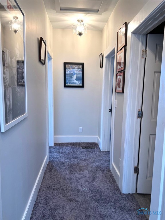 hallway featuring dark carpet