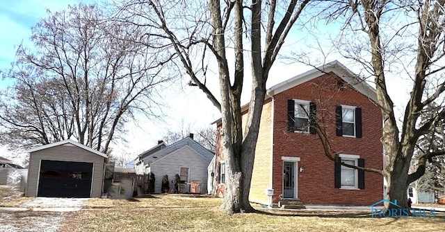 view of side of property featuring a garage, an outdoor structure, and a yard