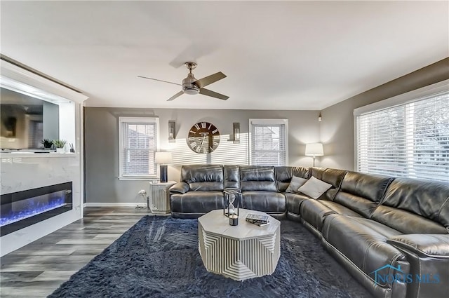 living room with hardwood / wood-style floors, ceiling fan, and a premium fireplace