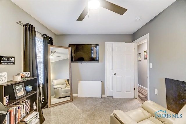 living area featuring ceiling fan and light colored carpet