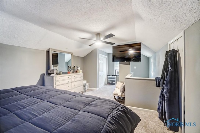 carpeted bedroom featuring a textured ceiling, ceiling fan, a closet, and lofted ceiling