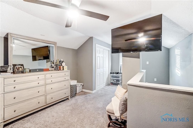 bedroom featuring a textured ceiling, light colored carpet, and vaulted ceiling