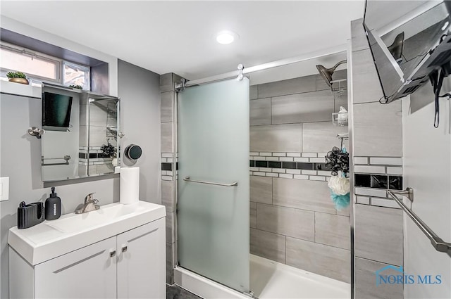 bathroom featuring vanity and a shower with shower door