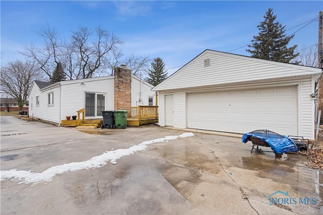 view of home's exterior with a garage, an outdoor structure, and a deck