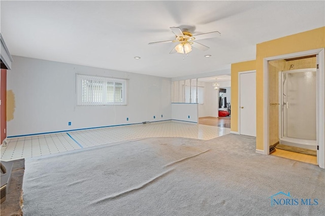 unfurnished living room featuring light colored carpet and ceiling fan