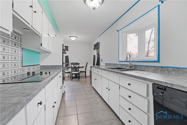 kitchen with sink, white cabinetry, tasteful backsplash, light tile patterned floors, and black appliances