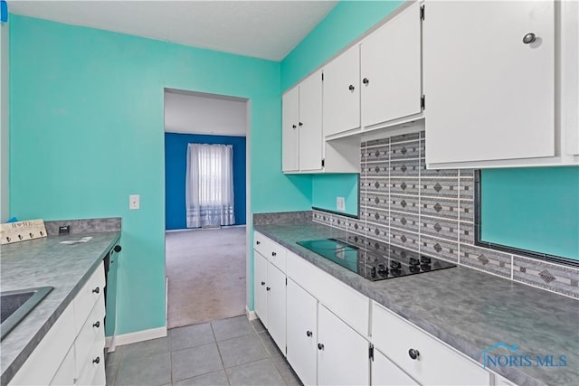 kitchen with white cabinetry, light tile patterned floors, black electric cooktop, dishwasher, and backsplash