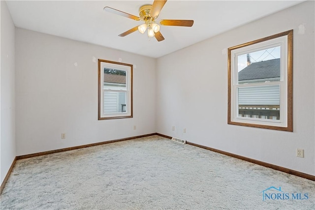 carpeted spare room featuring ceiling fan