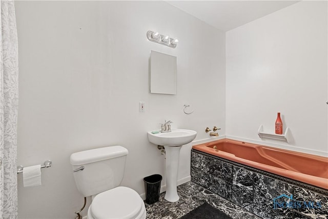 bathroom with toilet and tiled bath