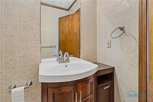 bathroom with vanity, ornamental molding, and tile walls