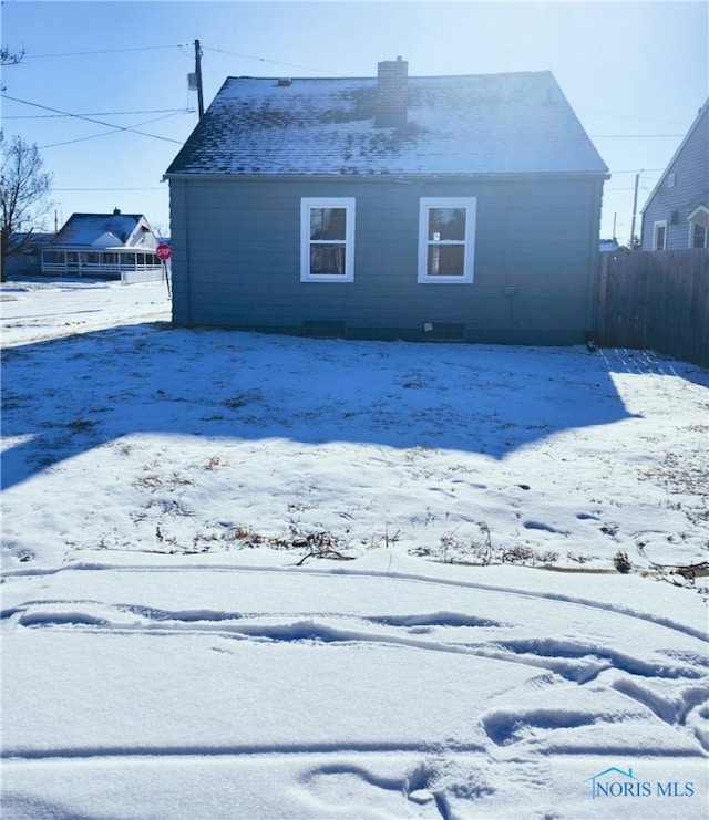 view of snow covered back of property