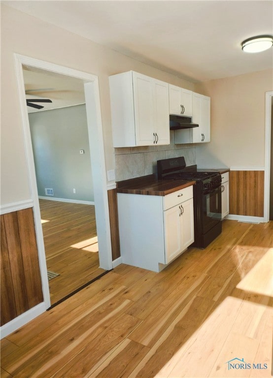 kitchen featuring ceiling fan, white cabinetry, light wood-type flooring, and gas stove