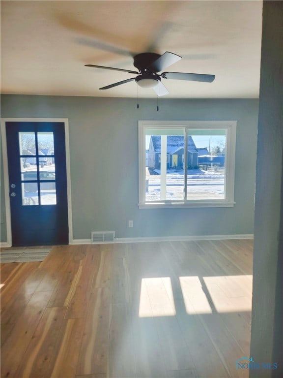 empty room featuring ceiling fan, light hardwood / wood-style flooring, and plenty of natural light