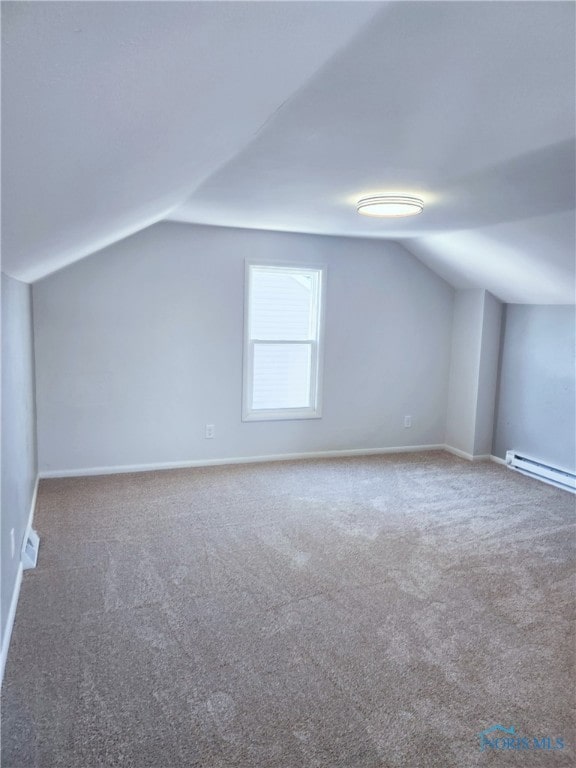 additional living space with baseboard heating, carpet floors, and vaulted ceiling