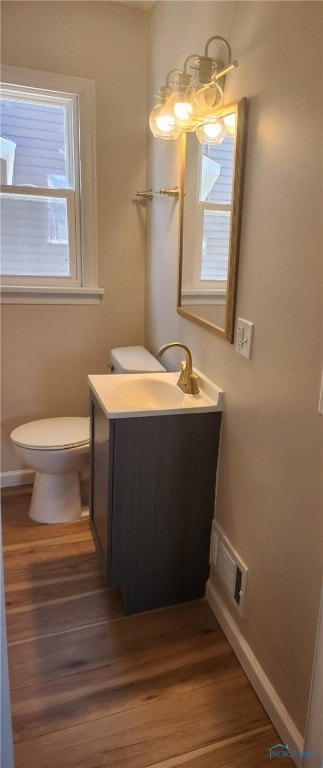 bathroom featuring toilet, wood-type flooring, and vanity