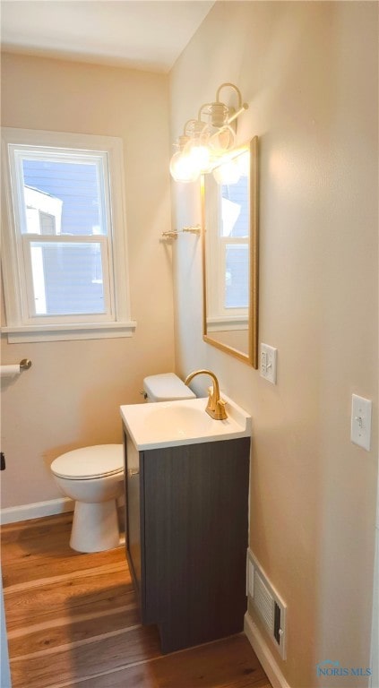 bathroom featuring toilet, vanity, and hardwood / wood-style flooring