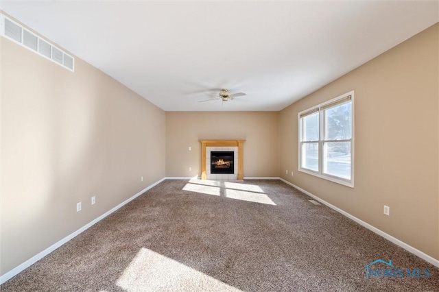 unfurnished living room with a fireplace, ceiling fan, and carpet