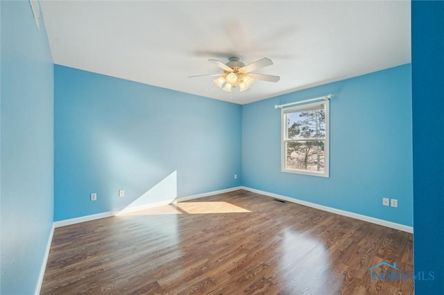 spare room with ceiling fan and dark hardwood / wood-style floors