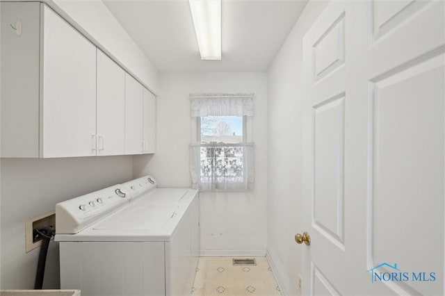 laundry area with separate washer and dryer and cabinets