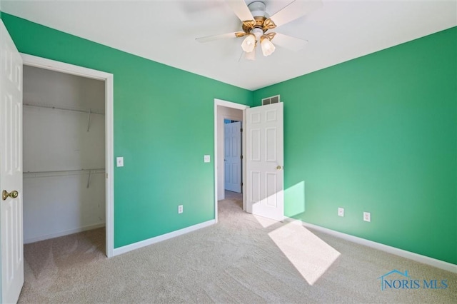 unfurnished bedroom featuring light colored carpet, ceiling fan, and a closet