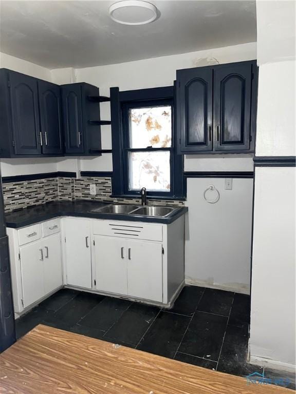 kitchen with white cabinetry, sink, and backsplash