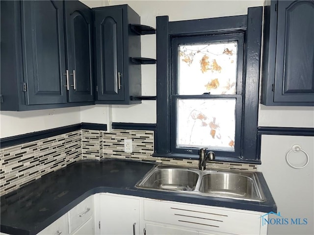 kitchen with white cabinetry, sink, and tasteful backsplash