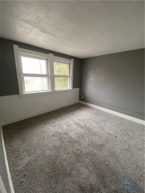 spare room with carpet and a textured ceiling