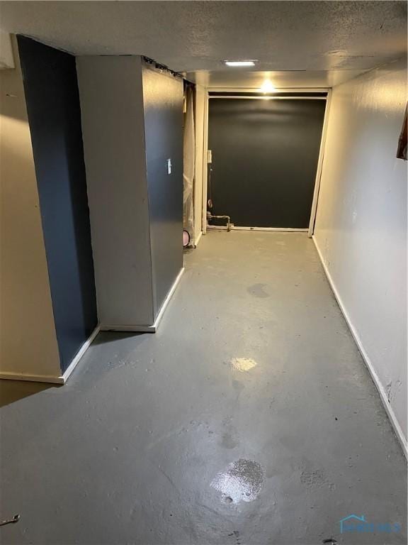 hall featuring concrete flooring and a textured ceiling