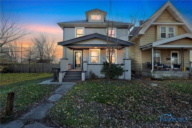 view of front of house featuring a lawn and covered porch