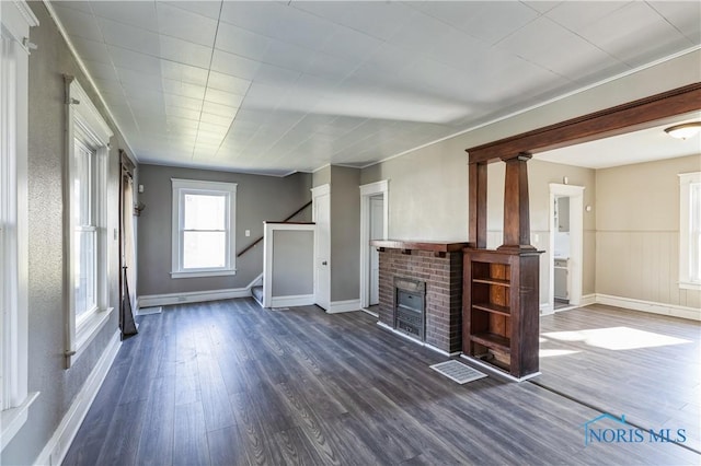 unfurnished living room featuring a fireplace and dark hardwood / wood-style flooring