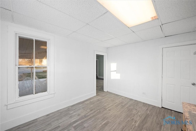 empty room featuring a drop ceiling and wood-type flooring