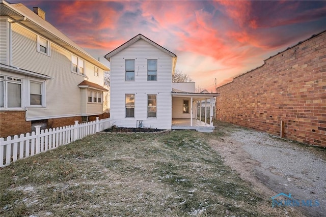 back house at dusk with a patio