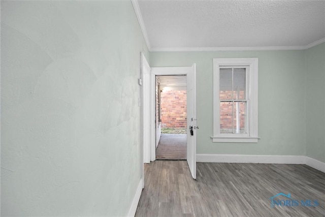 interior space with crown molding, hardwood / wood-style floors, and a textured ceiling