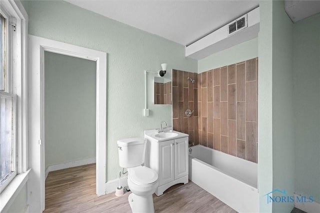 full bathroom featuring wood-type flooring, vanity, toilet, and tiled shower / bath