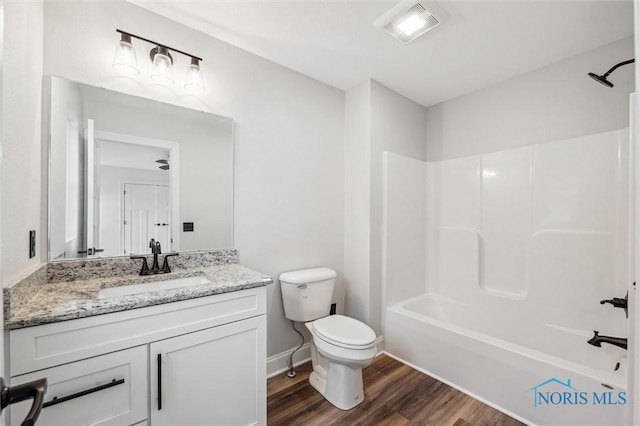 full bathroom with hardwood / wood-style floors, vanity, toilet, and shower / tub combination